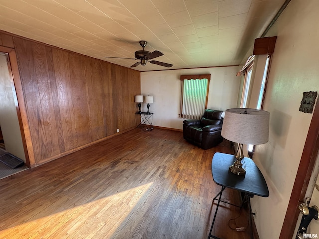 unfurnished room featuring wooden walls, hardwood / wood-style floors, and ceiling fan