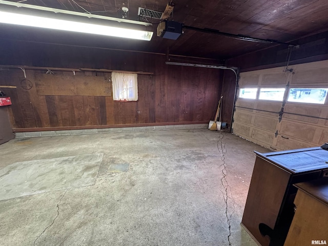 garage featuring wood ceiling, wood walls, and a garage door opener