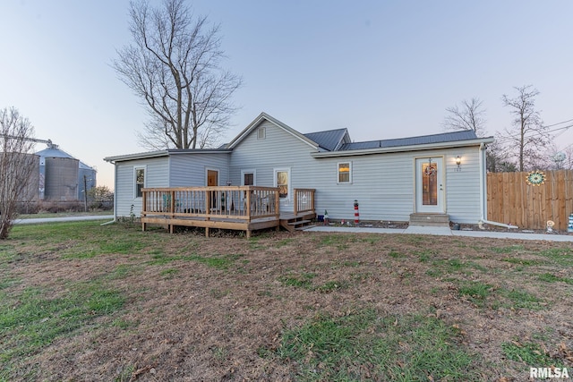 rear view of property featuring a yard and a deck