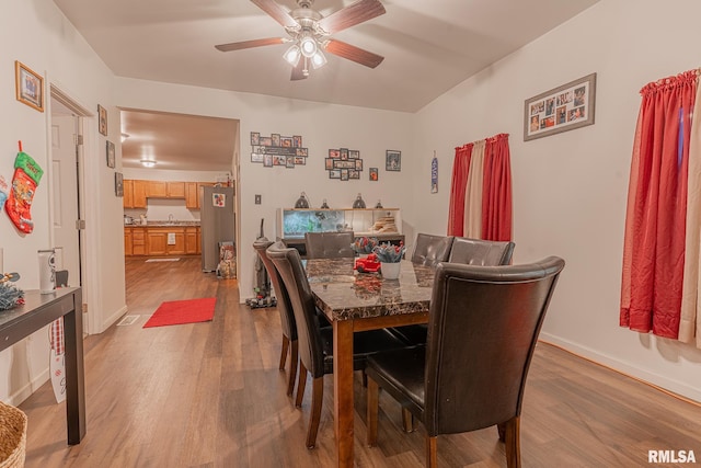 dining space featuring ceiling fan and light wood-type flooring