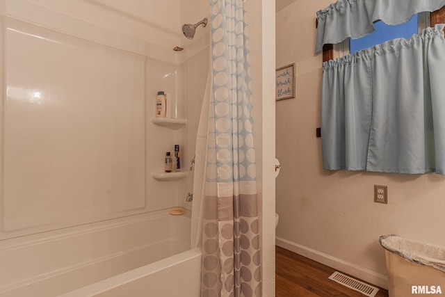 bathroom with wood-type flooring and shower / tub combo with curtain