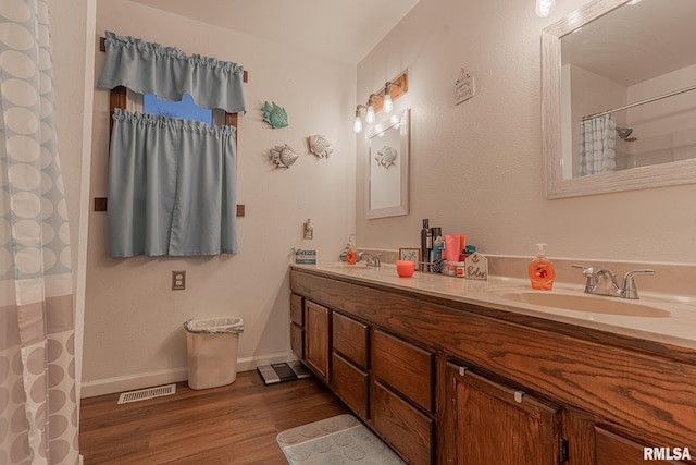 bathroom with a shower with shower curtain, vanity, and hardwood / wood-style flooring