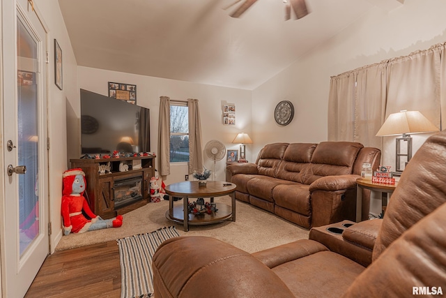 living room with ceiling fan, vaulted ceiling, and hardwood / wood-style flooring