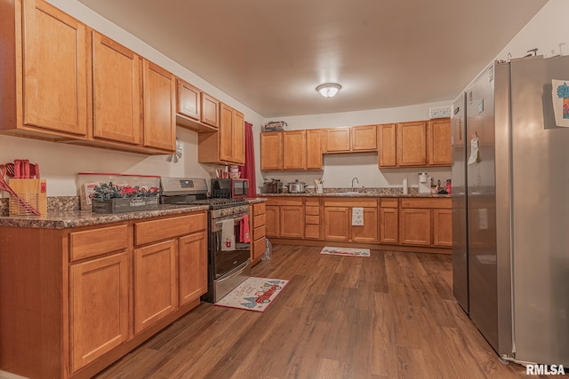 kitchen with sink, dark hardwood / wood-style flooring, and stainless steel appliances