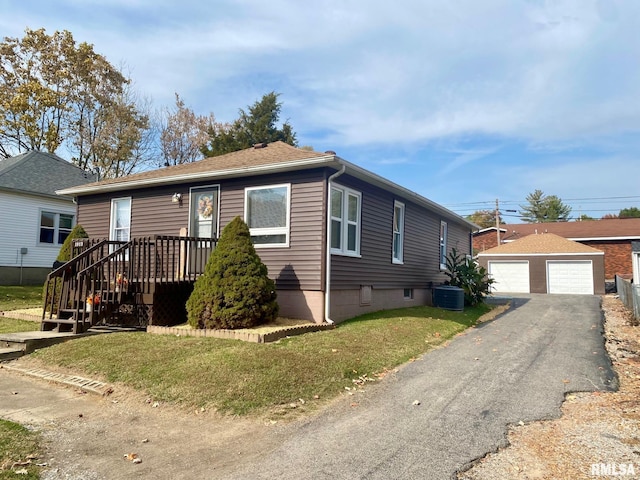 view of front of home with cooling unit, a garage, an outbuilding, and a front yard