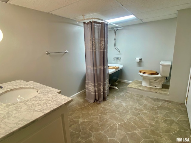 bathroom with a paneled ceiling, vanity, and toilet