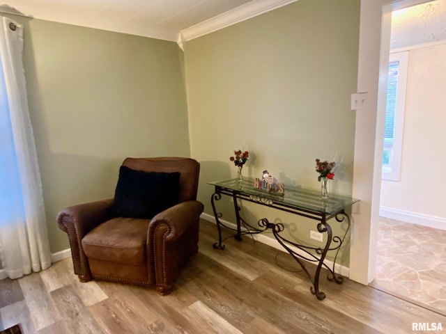 living area with light hardwood / wood-style flooring and ornamental molding