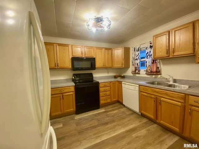 kitchen featuring ornamental molding, sink, black appliances, and light hardwood / wood-style floors