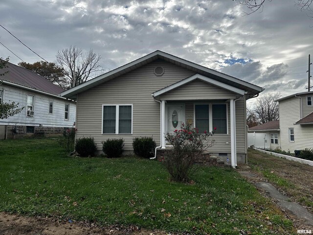 bungalow-style home with a front yard