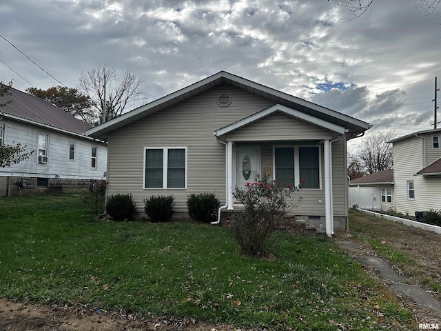 bungalow-style home with a front yard