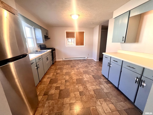 kitchen featuring appliances with stainless steel finishes, a textured ceiling, baseboard heating, and sink