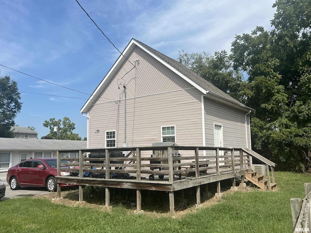 rear view of property with a deck and a lawn