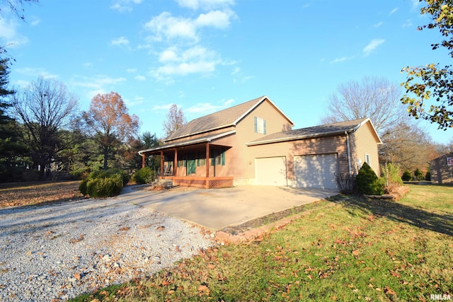 view of front of house featuring a front yard, a porch, and a garage