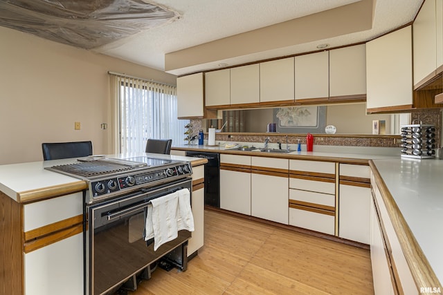 kitchen with sink, light hardwood / wood-style flooring, a textured ceiling, white cabinets, and black appliances