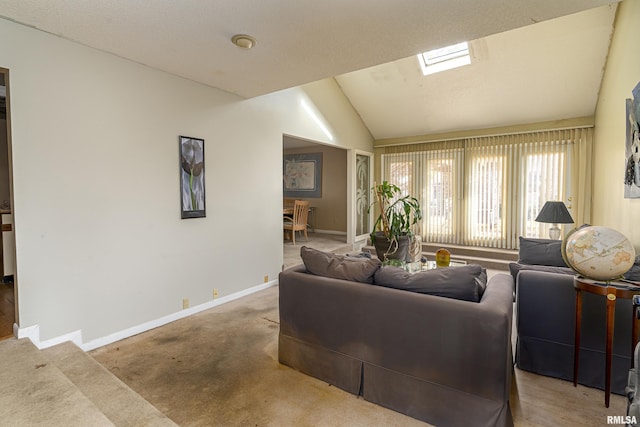 carpeted living room featuring lofted ceiling with skylight