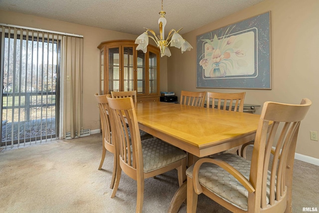 carpeted dining room with a textured ceiling and an inviting chandelier