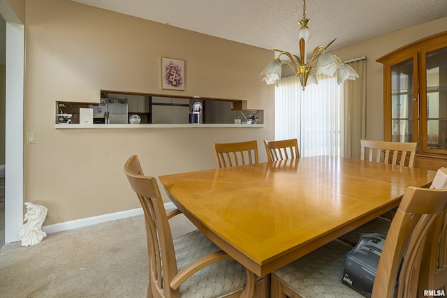 carpeted dining room featuring a textured ceiling and an inviting chandelier