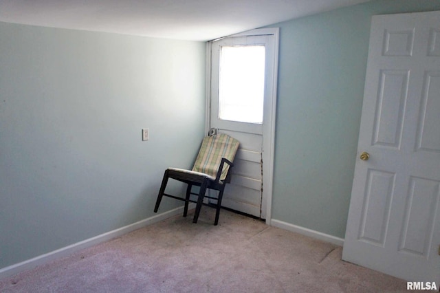 living area featuring light colored carpet and vaulted ceiling