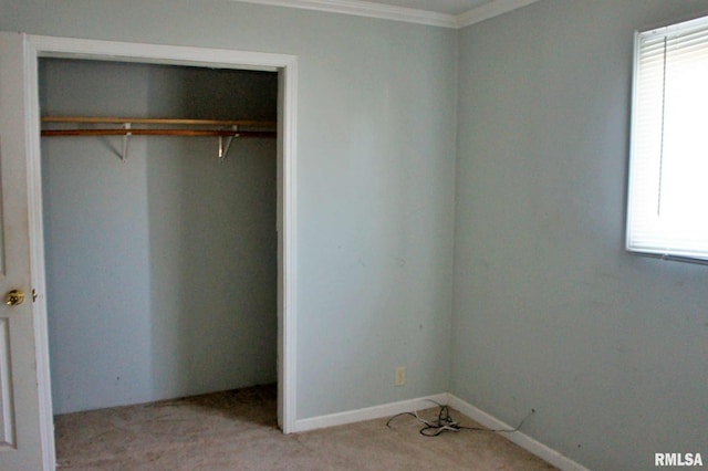 unfurnished bedroom featuring light colored carpet, crown molding, and a closet