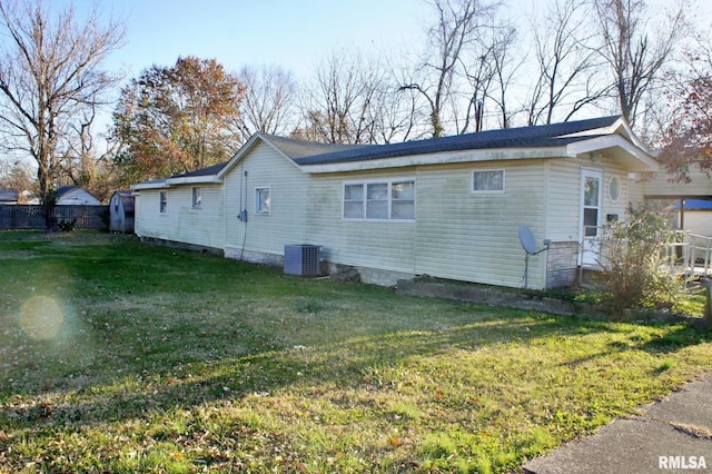 rear view of house featuring a yard and central air condition unit