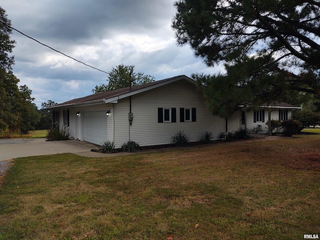 view of side of home featuring a garage and a lawn