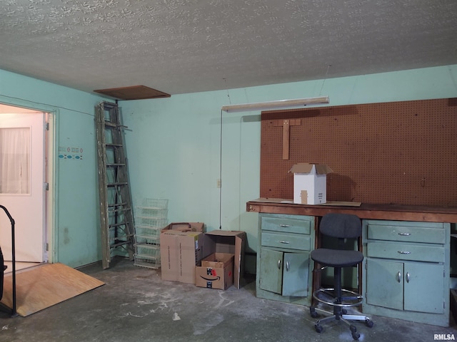 basement featuring a textured ceiling and a workshop area