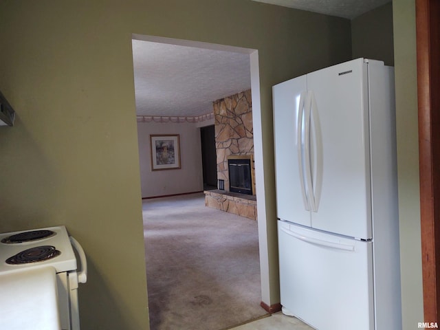 kitchen with a fireplace, white appliances, a textured ceiling, and light carpet