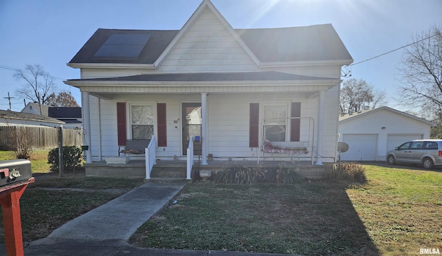 view of front of property with an outbuilding, a garage, a front lawn, and covered porch