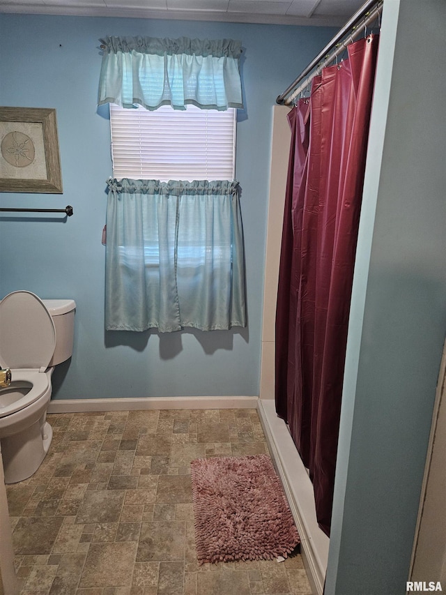 bathroom with a shower with curtain and toilet