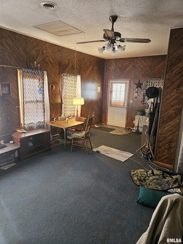 interior space with carpet, a textured ceiling, and ceiling fan