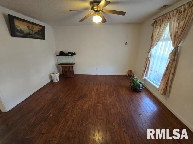 unfurnished room with a textured ceiling, dark hardwood / wood-style flooring, and ceiling fan