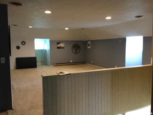 cinema room with light colored carpet and a baseboard radiator