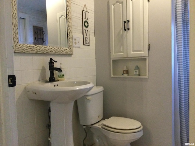 bathroom featuring backsplash, toilet, and tile walls