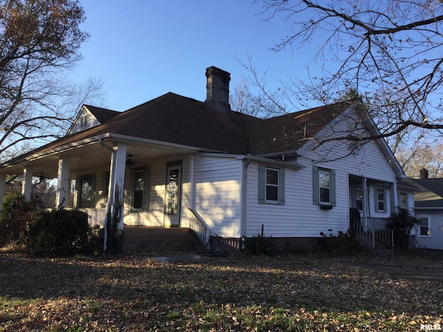 view of side of home featuring covered porch