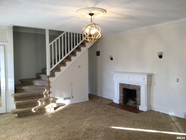 unfurnished living room featuring carpet flooring, ornamental molding, a textured ceiling, an inviting chandelier, and a fireplace