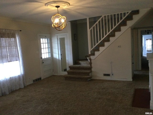 carpeted foyer featuring a textured ceiling, crown molding, and a notable chandelier