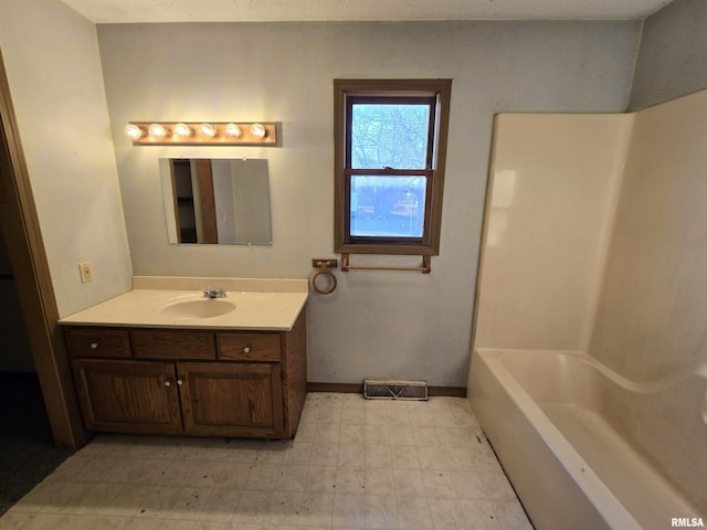 full bathroom with visible vents, vanity, baseboards, and tile patterned floors