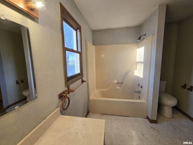 bathroom with shower / bathtub combination, toilet, vanity, a textured ceiling, and tile patterned floors