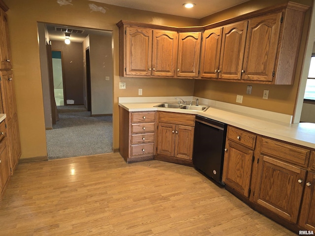 kitchen with light countertops, brown cabinetry, light wood-style floors, a sink, and dishwasher