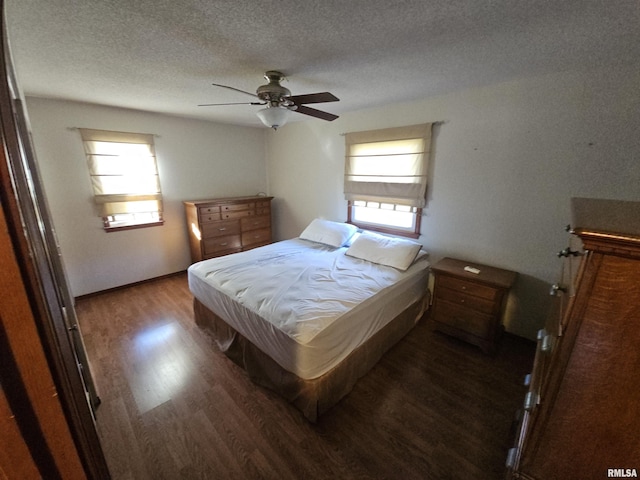 bedroom featuring ceiling fan, dark hardwood / wood-style flooring, and a textured ceiling