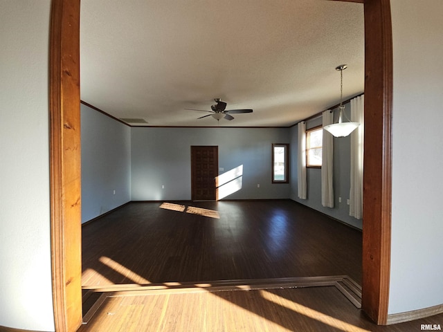 unfurnished room featuring hardwood / wood-style flooring, ceiling fan, ornamental molding, and a textured ceiling