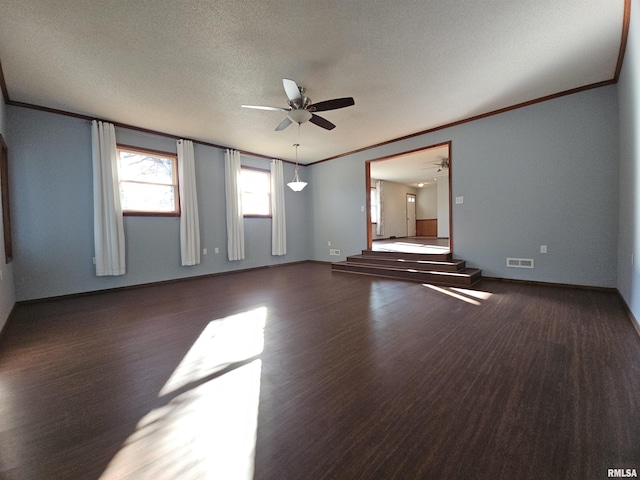 empty room featuring ornamental molding, a textured ceiling, ceiling fan, and dark wood-type flooring