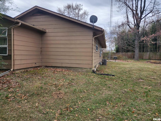 view of side of home featuring a yard and central AC unit