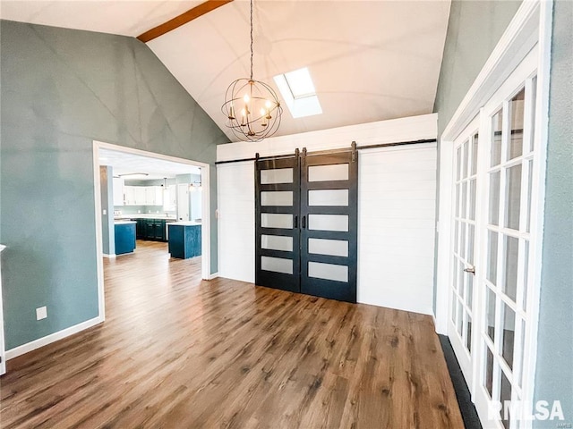 entryway with french doors, a barn door, lofted ceiling with beams, a chandelier, and wood-type flooring