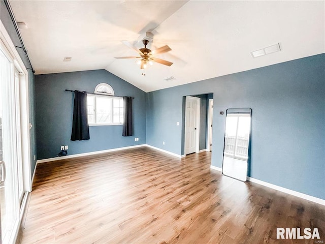 unfurnished room with ceiling fan, lofted ceiling, and light wood-type flooring