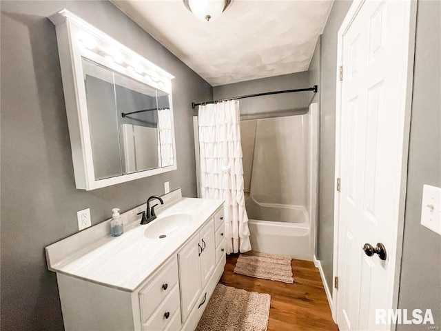 bathroom with hardwood / wood-style floors, vanity, and shower / bath combo with shower curtain