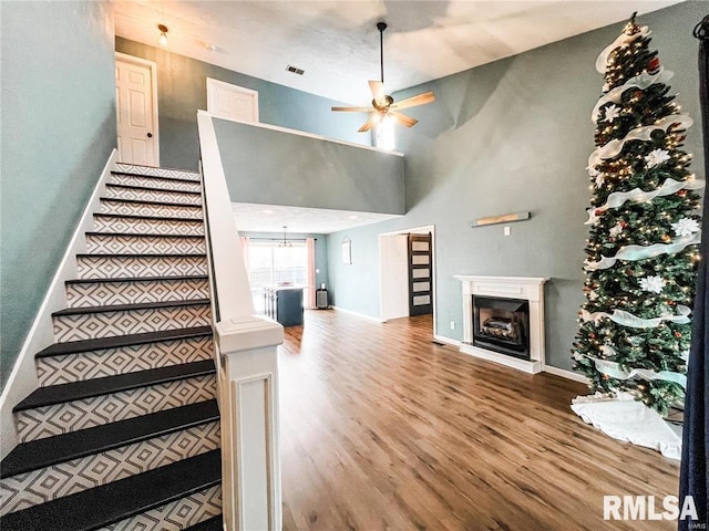 stairway with ceiling fan and hardwood / wood-style floors