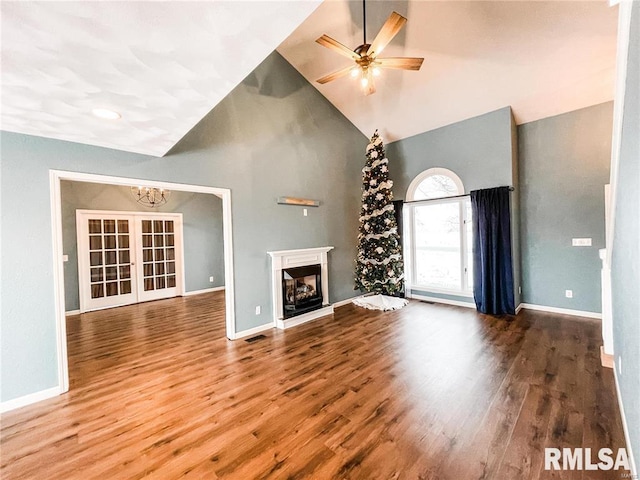 unfurnished living room with wood-type flooring, high vaulted ceiling, french doors, and ceiling fan