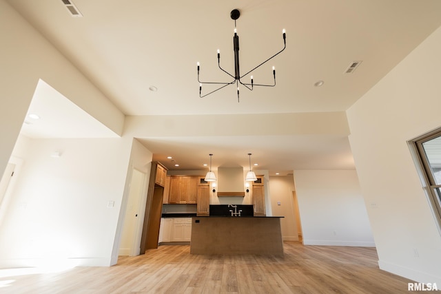 kitchen featuring a chandelier, a center island, light hardwood / wood-style floors, and hanging light fixtures