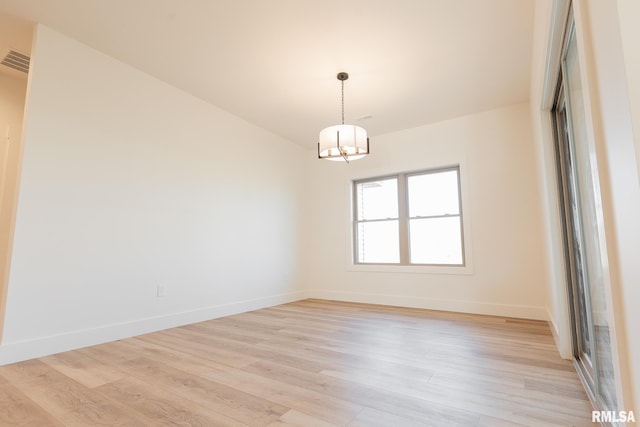 unfurnished room with light hardwood / wood-style floors and a chandelier